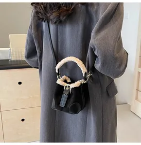 Detail einer Plüsch-Lammwoll-Eimertasche, crossbody getragen in minimalistischem Design