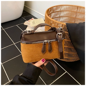 Detail of square brown leather and mustard suede crossbody bag with metal zipper