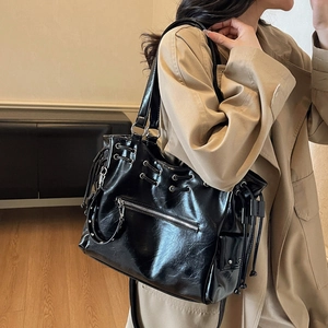Large black shiny PU leather tote bag with drawstring detail and silver eyelets for daily use