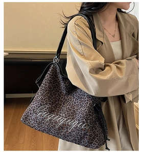 Detail der Leo-Print-Tasche mit weißer Stickerei und verstellbarem schwarzen Schultergurt