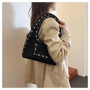 Détail d'un sac sous le bras en daim noir vintage avec des rivets argentés sur un mannequin