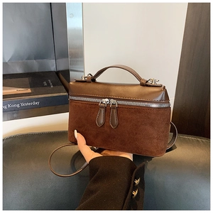 Detail view of the brown leather and suede patchwork mini square bag with silver zippers