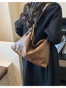 Vue détaillée d'un sac hobo marron foncé vintage avec décor de glands en perles de bois
