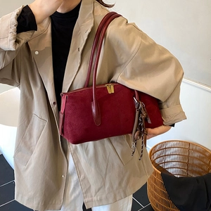 Burgundy suede shoulder bag with dual gold zippers and minimalist rectangular shape