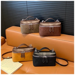 Detail of vintage suede box bags in four colors showing leather stitching and straps