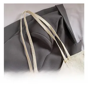 Gros plan détaillé sur les anses d'un sac cabas en toile blanche au grain naturel