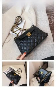 Gros plan du sac bandoulière matelassé noir avec boucle dorée et détail de bandoulière