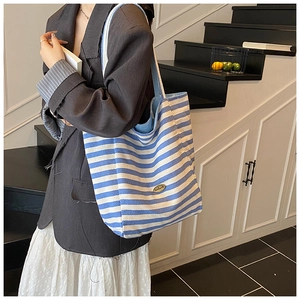 Blue and white striped canvas tote bag shown as a large capacity shoulder bag for commuting