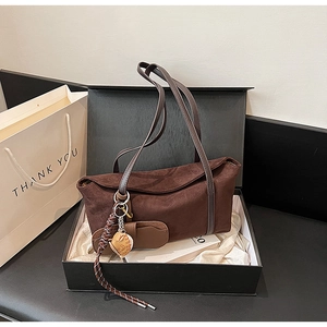 Macro detail of brown suede shoulder bag in premium gift box with thank you bag