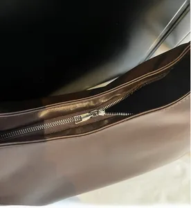 Détail de la fermeture éclair en métal argenté sur le sac fourre-tout marron foncé