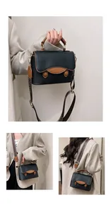 Détail du sac en cuir noir avec bordure marron et bandoulière tissée élégante