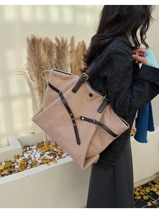 Close-up of a large pink fleece tote bag with brown leather straps for autumn style