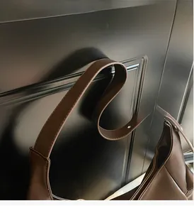 Détail de la large bandoulière et des coutures nettes de ce sac cabas en cuir marron