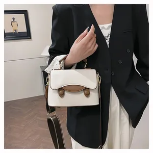Détails du sac en cuir grainé avec coutures contrastées et large bandoulière imprimée
