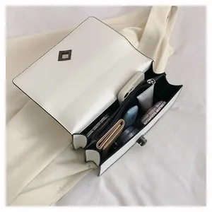 Detail view of the multi-compartment interior for cream PU shoulder bag with metal lock