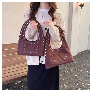 Détails de sacs sous les bras en daim marron avec des rivets argentés et un design rétro chic