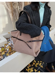 Detail of light brown fleece tote bag with brown leather straps and metal buckle closure