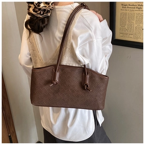 Detailed view of dark brown woven texture shoulder bag with stylish knot strap detail