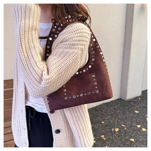 Détail des rivets argentés sur le sac hobo en daim marron foncé de style bohème