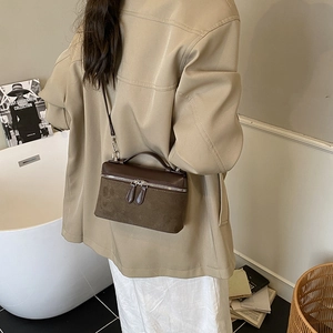Chic dark brown square crossbody bag with textured leather paneling and chain strap
