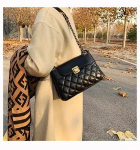 Détail du sac bandoulière en cuir matelassé noir avec fermoir doré et bandoulière