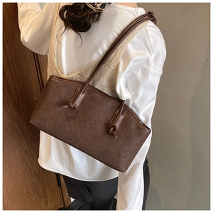 Detailed view of deep brown woven leather shoulder bag with a stylish knot handle detail