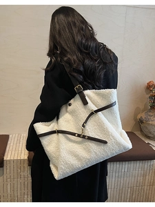 Vue détaillée du sac cabas en peau de mouton blanche avec lanières en cuir marron et boucles
