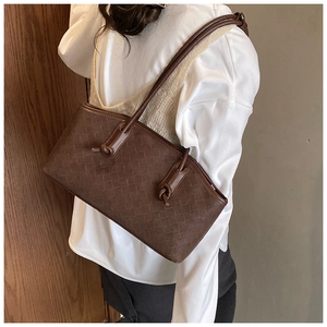 Detail of dark brown woven leather tote with intricate knots and Intrecciato pattern