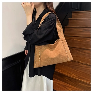 Brown suede shoulder bag featuring vintage golden rivets on edges and strap detail