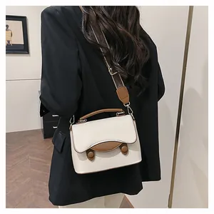 Vue détaillée du sac bandoulière crème et marron avec texture cuir et bandoulière