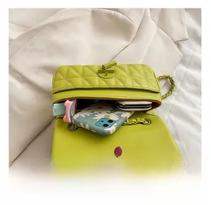 Detail view of the green quilted flap bag interior showing capacity for phone and wallet