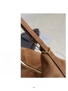 Close-up of brown leather texture with golden hardware and precise stitching details