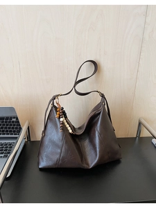 Gros plan détaillé d'un grand sac cabas marron foncé en cuir PU avec glands perlés