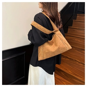 Detailed view of brown velvet shoulder bag with trendy gold metal grommet eyelets