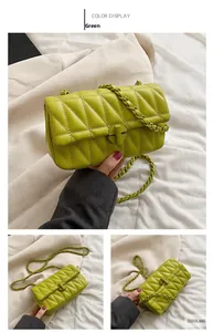 Macro shot of green quilted crossbody bag with circular twist lock and chain strap details