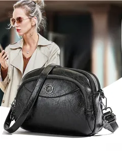 Detail of black soft leather crossbody bag with vintage texture and golden kangaroo logo