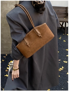 Brown quilted shoulder bag with knotted strap details shown in an autumn street setting