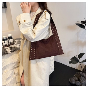 Detail of dark brown suede shoulder bag featuring vintage golden rivet stud embellishments