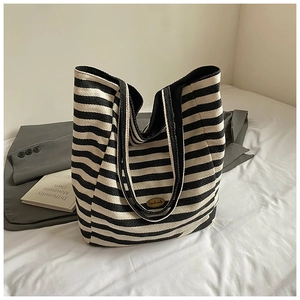 Detail of handmade logo on striped canvas tote bag with large capacity shoulder straps