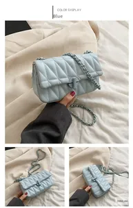 Detail of light blue quilted crossbody bag with chain strap and twist lock