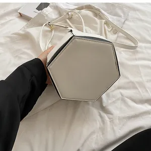 Detailed bottom view of a cream hexagonal bucket bag with black contrasting edges
