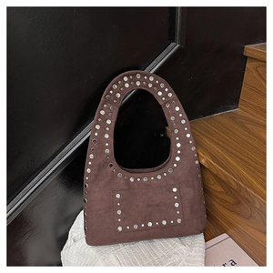 Gros plan du sac sous le bras en daim marron avec rivets métalliques argentés décoratifs
