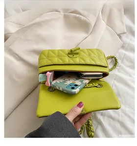 Detail view of the green quilted chain bag interior showing storage for essentials