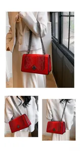 Detail of red snake-patterned leather bag with silver chain and diamond metal clasp