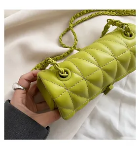 Close-up of lime green quilted cylinder bag with white contrast stitching and chain
