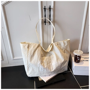 Détail du grand sac cabas blanc cassé avec texture plissée et style minimaliste