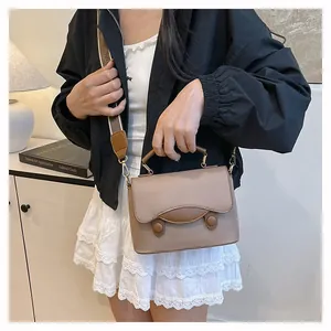Détail d'un sac à bandoulière en cuir vintage avec une large sangle tissée brune