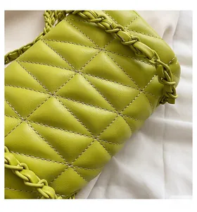 Detail view of lime green quilted handbag with leather-woven chain strap and texture