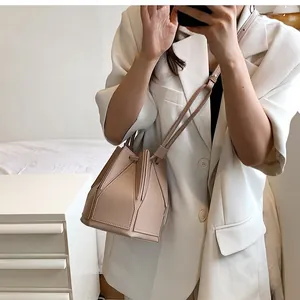 Detail showing geometric paneled folding structure and matte leather texture of the bag