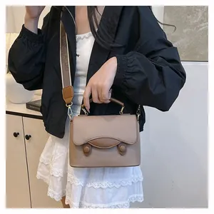 Détail du petit sac bandoulière taupe avec rabat festonné et large bandoulière